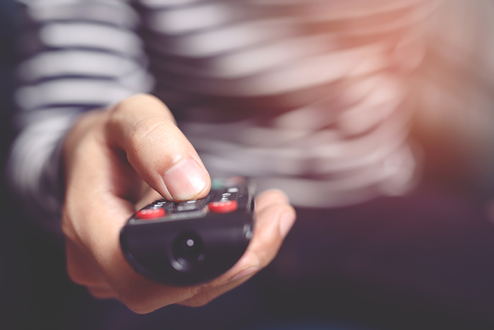 Photo of a hand holding a remote control